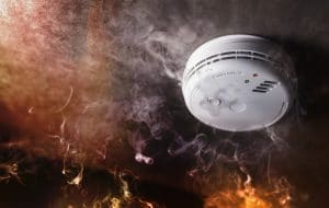 Smoke detector and fire alarm in action background with copy space